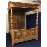 A pine king size four poster bed with panelled canopy & carved decor