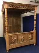 A pine king size four poster bed with panelled canopy & carved decor