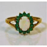 A 9ct gold ring set with emerald & opals size R/S