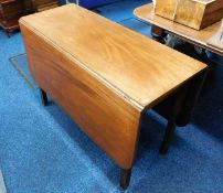 An antique mahogany drop leaf table