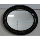 An oval mirror with decorative frame 25in at wides