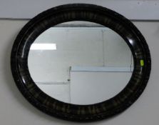 An oval mirror with decorative frame 25in at wides