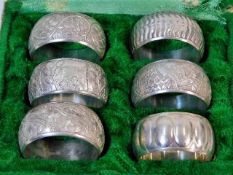 A case of six decorative white metal napkin rings