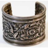 A white metal bangle with relief decor