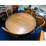 An oval Ercol drop leaf elm dining table with four