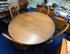 An oval Ercol drop leaf elm dining table with four