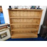 A low level pine bookcase with four shelves includ