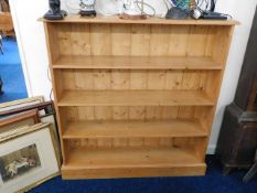 A low level pine bookcase with four shelves includ