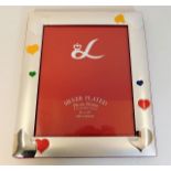 A silver plated photo frame with heart decor