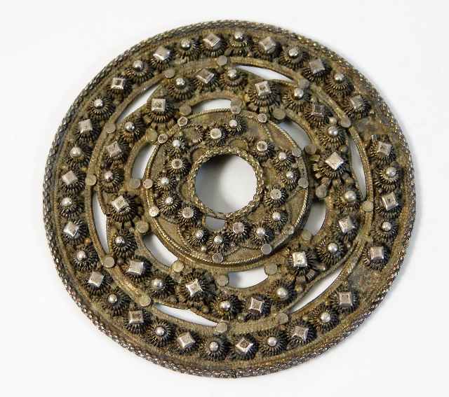 A white metal roundel with applied similar "jewels