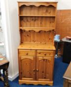 A small cottage style pine dresser with two shelve