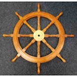 A wooden reproduction yacht wheel with brass centr