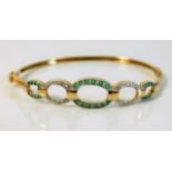 A 9ct gold bangle set with diamonds & emeralds 6.5