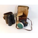 A pair of binoculars twinned with a boxed gas mask