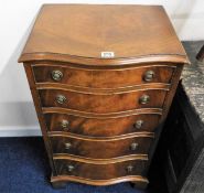 A five drawer serpentine fronted chest of drawers