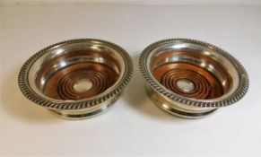 Two antique silver plated wine coasters