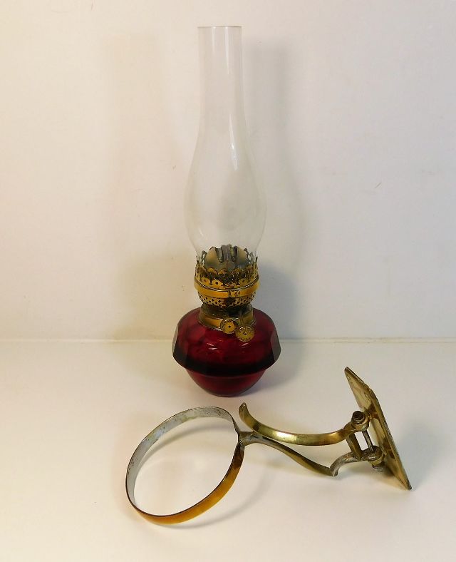 A c.1900 brass mounted ruby glass oil wall lamp