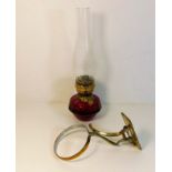 A c.1900 brass mounted ruby glass oil wall lamp