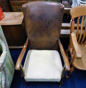 A low level arm chair with leather back & embossed