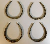 A set of four silver horseshoe napkin ring holders
