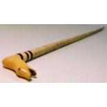 A 19thC. whale bone child's walking cane with carv