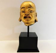 An antiquated Chinese gilded stoneware head mounte