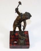 A small antique bronze of cherub working with anvi