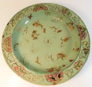 A large possibly 18thC. Oriental celadon style charger 15.25in diameter with painted moths & foliate