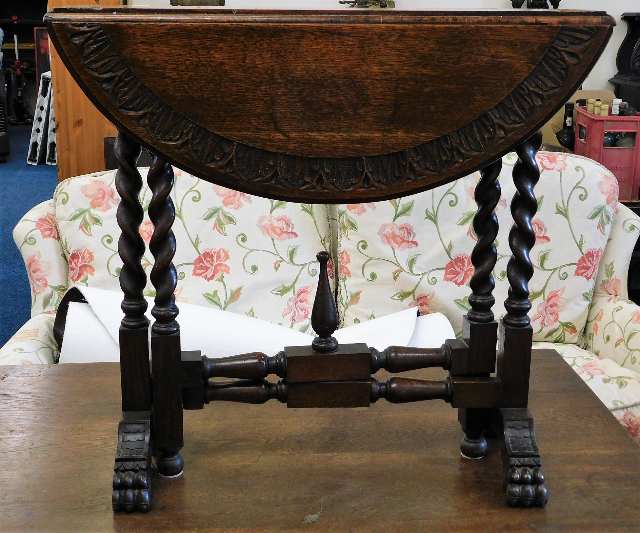 An early 20thC. oak drop leaf occasional table wit