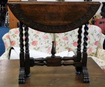 An early 20thC. oak drop leaf occasional table wit