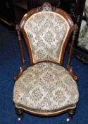 An antique low level walnut nursing chair