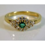 An 18ct gold diamond & emerald ring set with appro