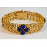 An 18ct gold bracelet with enamelled decor & red s
