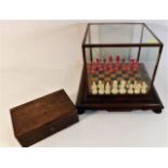 An antique German polished bone chess set within glass case & chess pieces box