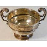 A plain silver bowl with two handles, some faults