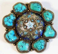 A decorative silver brooch set with turquoise & ce