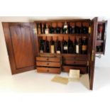 An antique apothecary cabinet & contents with fitt