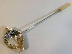 An antique French silver ladle with ivory handle