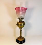 A 19thC. brass oil lamp with etched cranberry glas