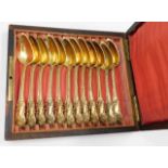 A set of six 19thC. decorative French silver gilt spoons set in a rosewood box inlaid "Cafe" to the