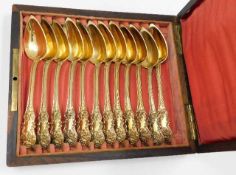A set of six 19thC. decorative French silver gilt spoons set in a rosewood box inlaid "Cafe" to the