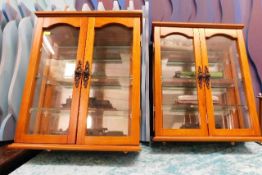 A pair of wall mounted display cabinets with fixed