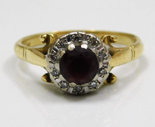 An 18ct gold ring set with diamonds & red stone a/