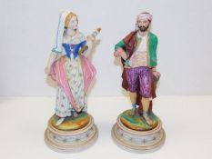 A pair of 19thC. continental bisque figures 13in tall, loss to ladies small finger