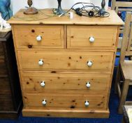 A pine chest of five drawers with ceramic fittings