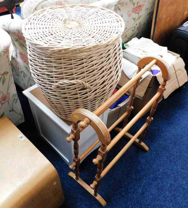 A pine towel rail twinned with a wicker laundry ba