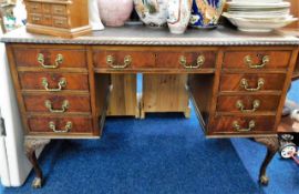 A decorative antique nine drawer desk with brass h