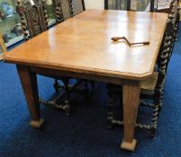 An antique extendable oak table with winder