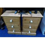 A pair of pine bedside cabinets with ceramic fitti