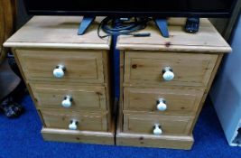 A pair of pine bedside cabinets with ceramic fitti